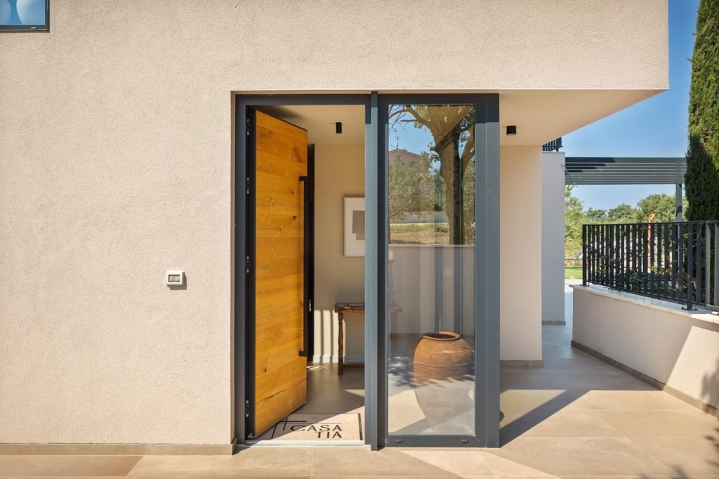 Modern living room with large glass walls and pool view in luxury villa Casa Tia Istria