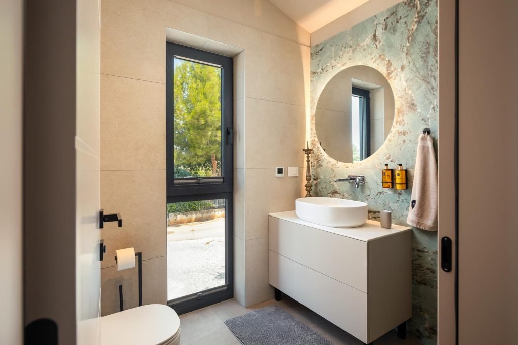 Modern bathroom with vanity and round mirror in luxury villa Casa Tia I in Istria