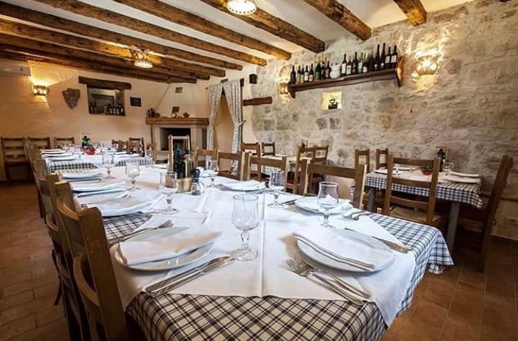 Traditional Istrian konoba dining room with stone walls and rustic wooden tables, authentic dining near Poreč