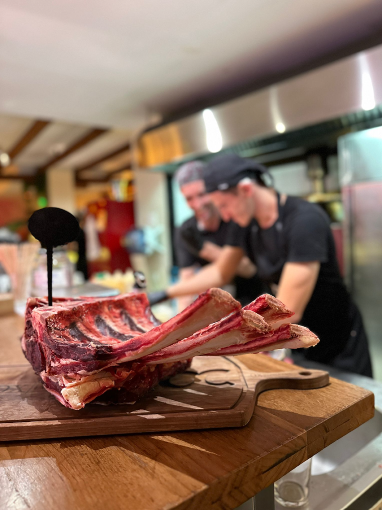 Chef preparing grilled steak at OX Food & Fire restaurant in Poreč